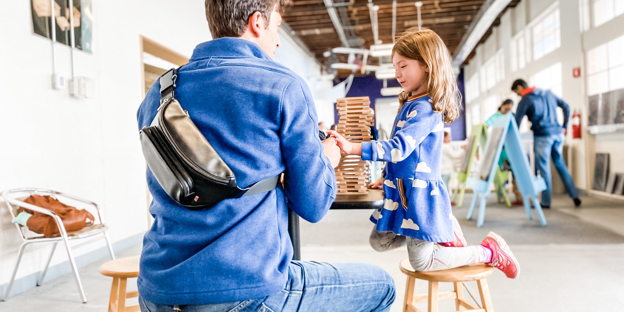 Dad wearing Kibou diaper bag while playing with daughter