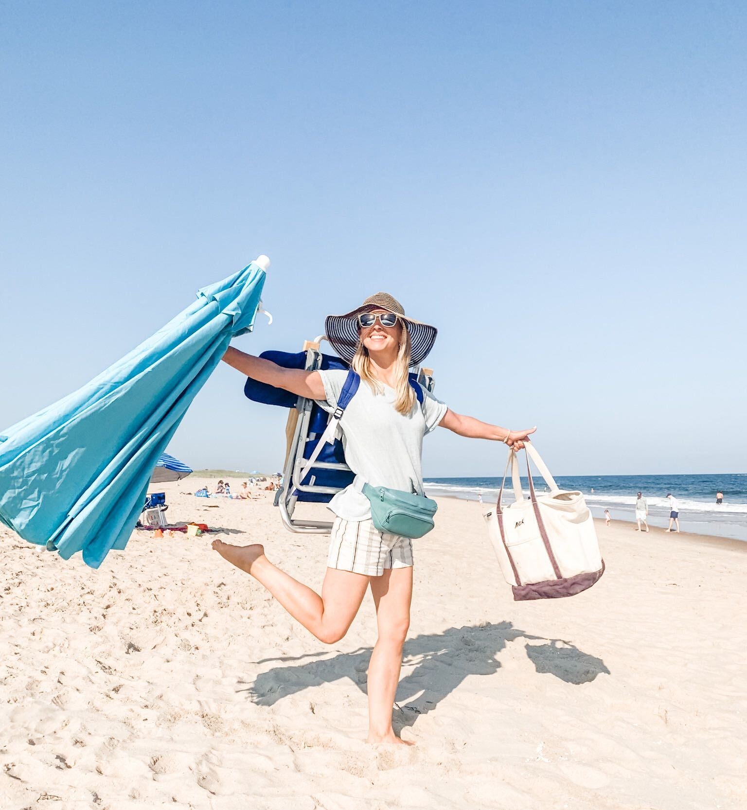 mom on the beach wearing a Kibou fanny pack diaper bag