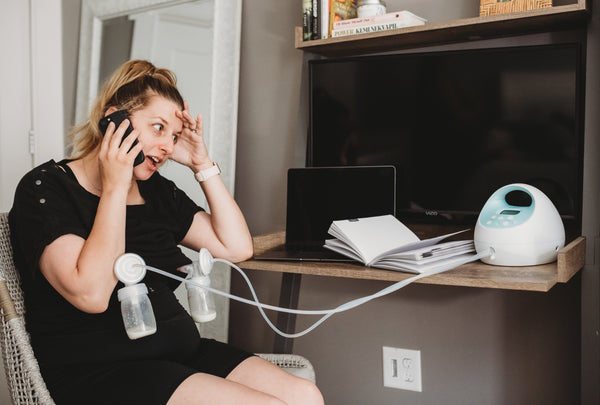 Woman back to work after maternity leave stressed out and trying to pump while on a work call